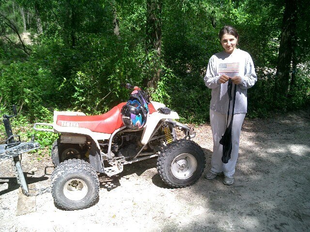 Mila with a Yamaha ATV on a wooded trail